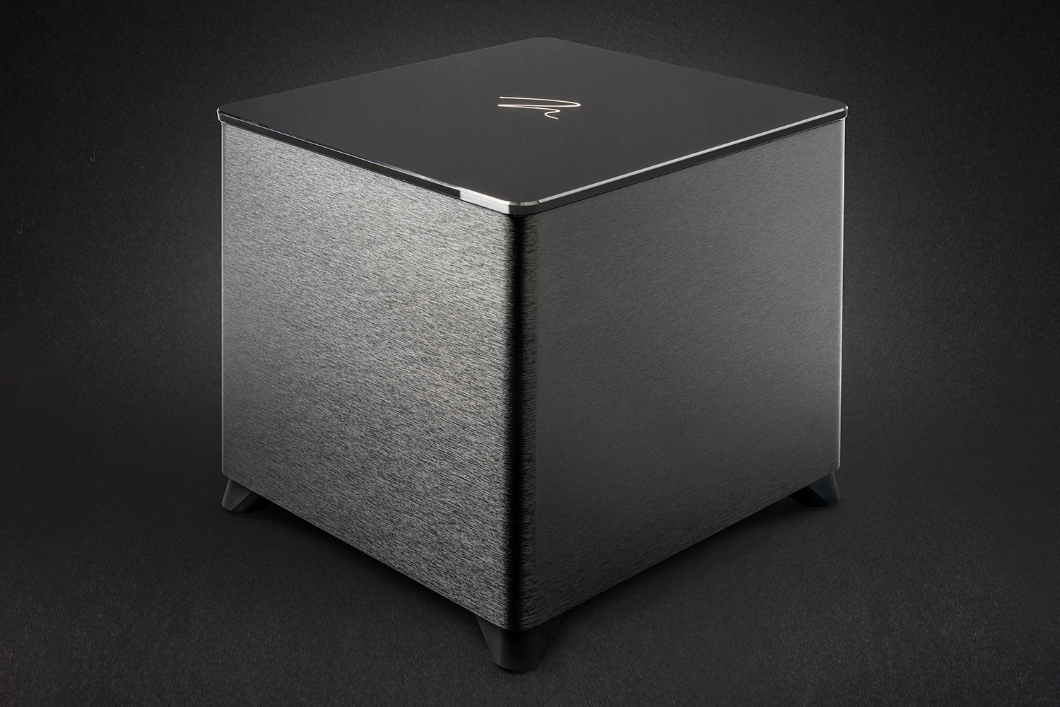 Subwoofer Dynamo Foundation 12 preto em foto de estúdio sobre fundo escuro, com topo em alto brilho.