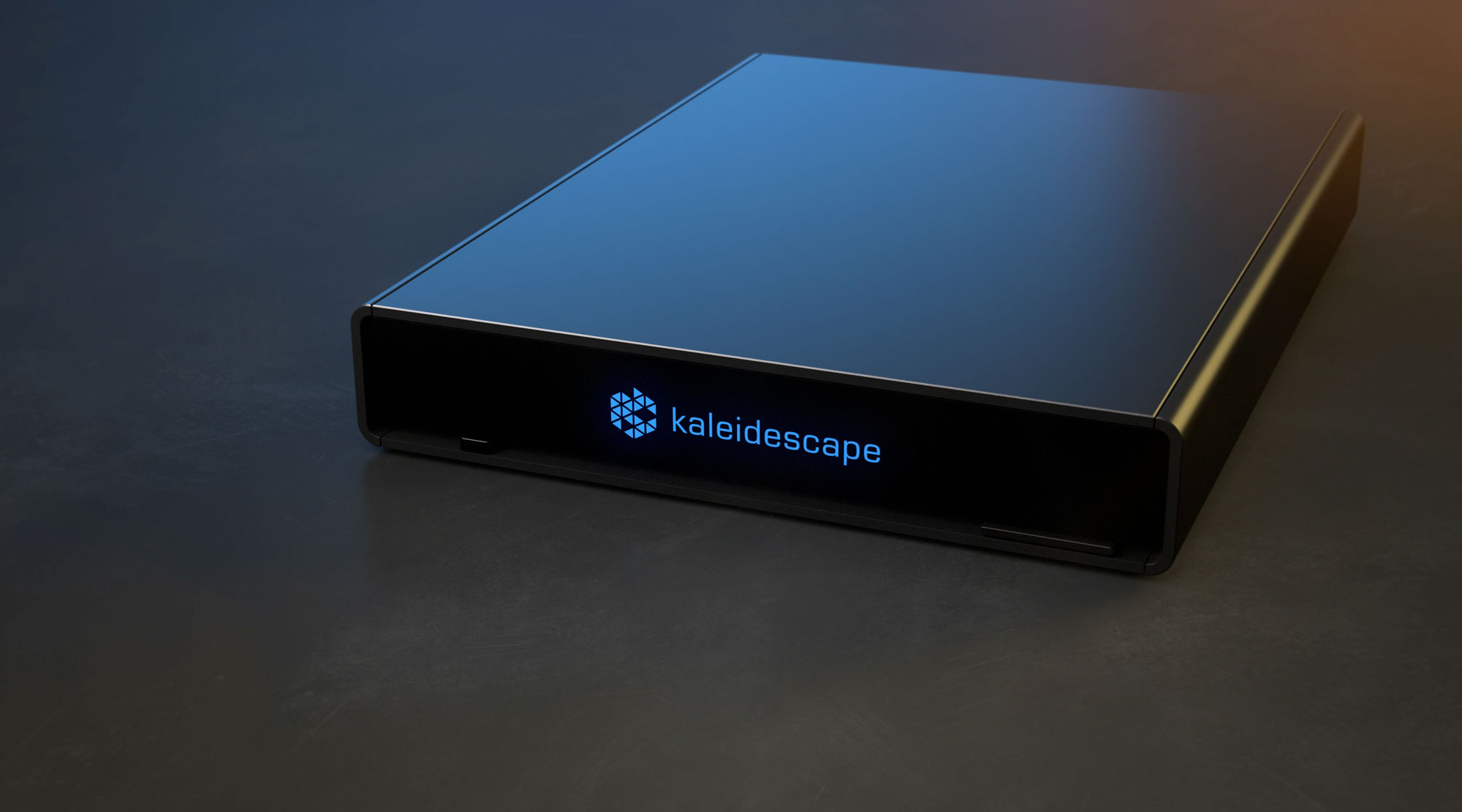 Player Kaleidescape Strato V, chassi preto de baixo perfil em alumínio, visto em três quartos sobre superfície escura